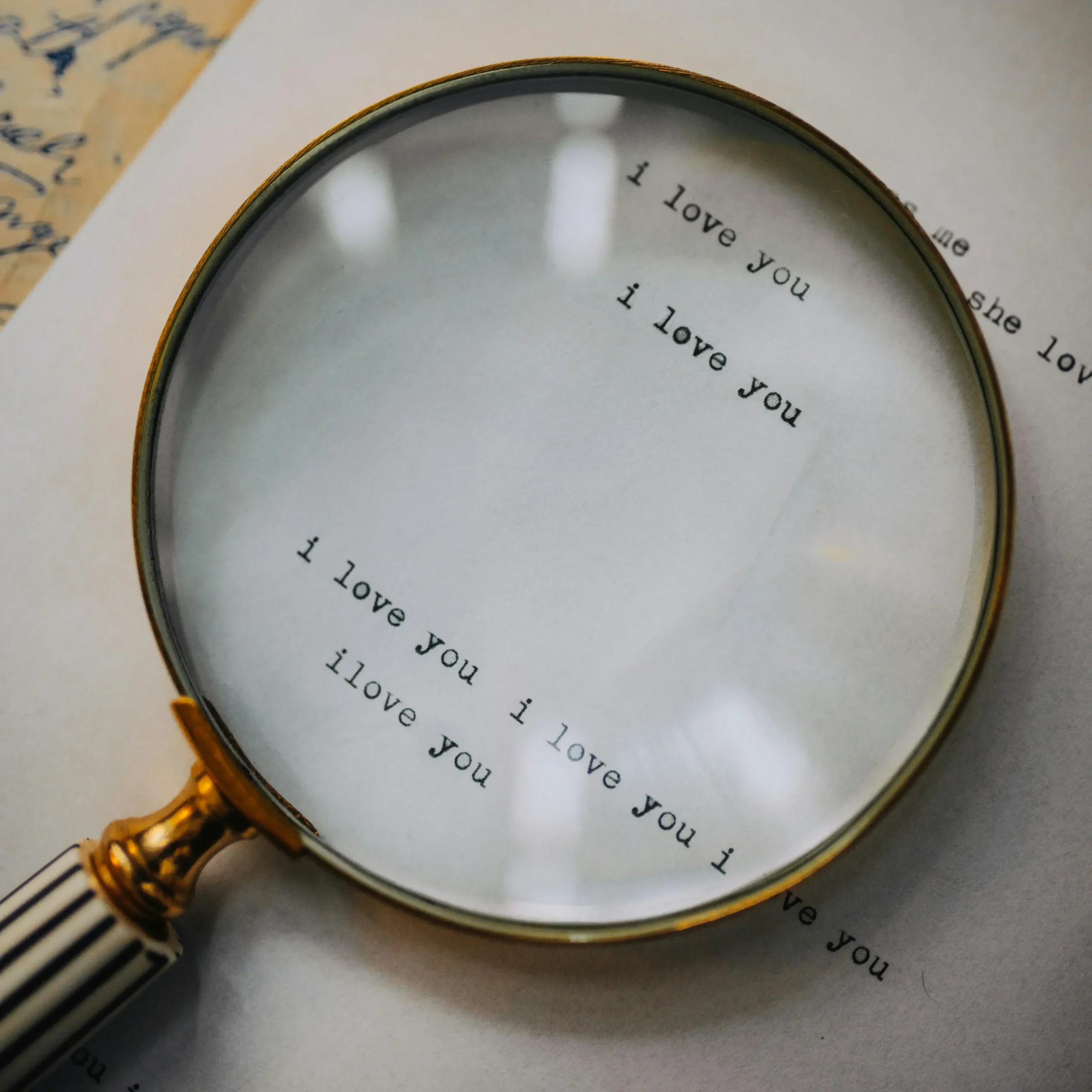 Magnifying glass enlarging the words “I love you” on a page, symbolizing the close examination of love and relationships that occurs in relationship OCD.