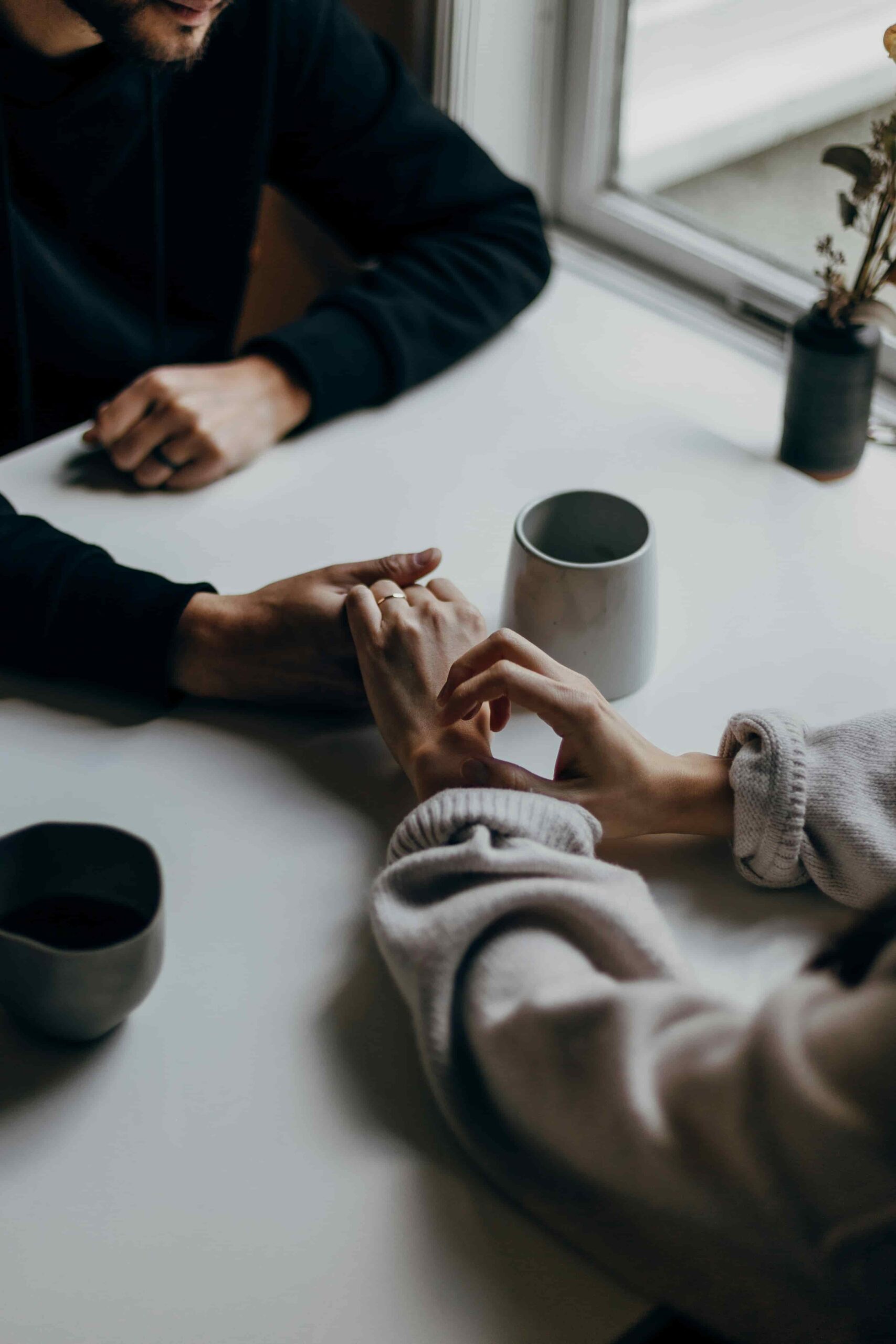 A couple holding hands during a conversation about relationship challenges, communication, and emotional connection.